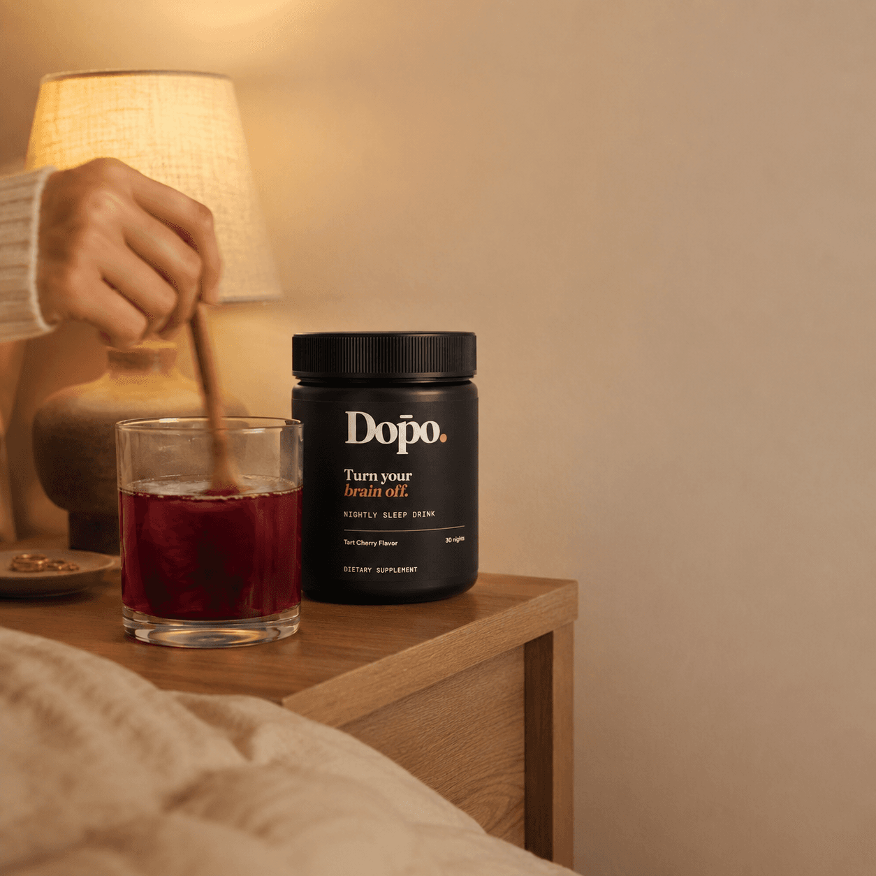 Dōpo tub and a ruby drink being stirred on a warm bedside table