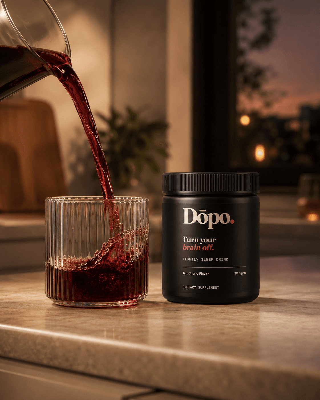 Dōpo tart-cherry drink being poured into a ribbed glass beside the tub in warm evening light